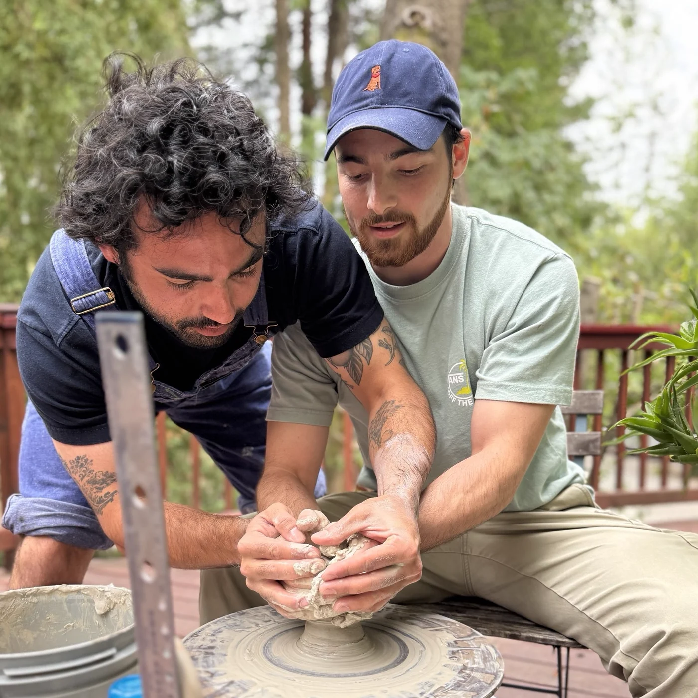 Two Gartner Lab members shape clay together at a pottery wheel during the 2025 lab retreat.